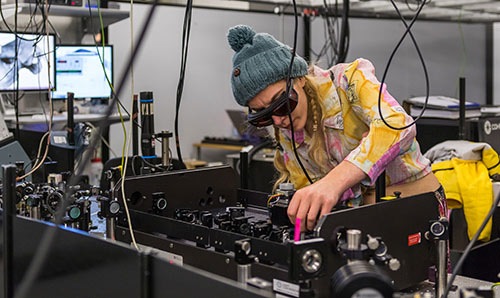 Researcher crouched over equipment in the PSI