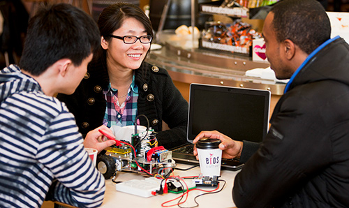 Three people discussing work in a University cafe