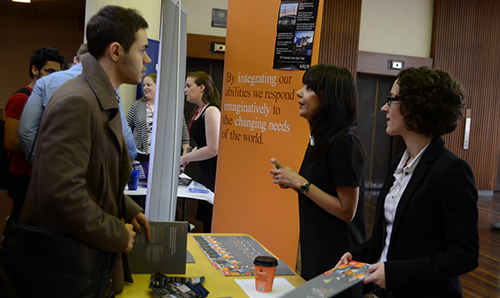 Two businesswomen in conversation with a student