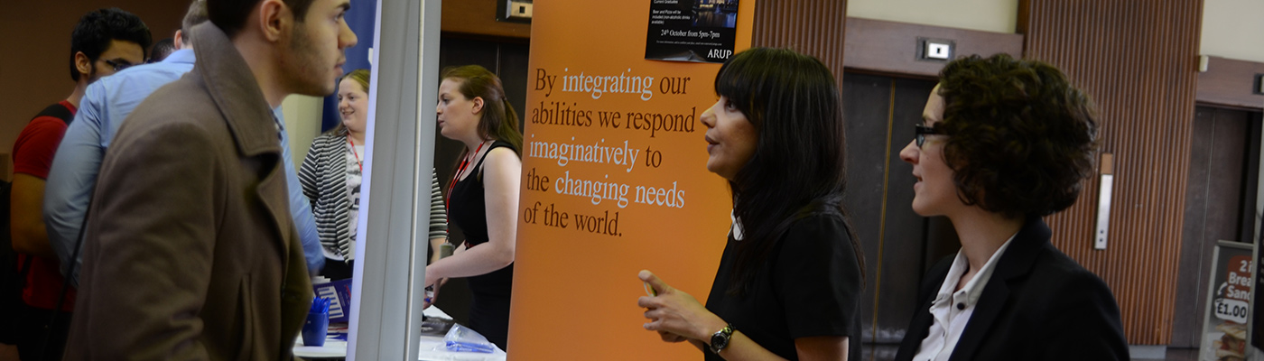 Two businesswomen in conversation with a student