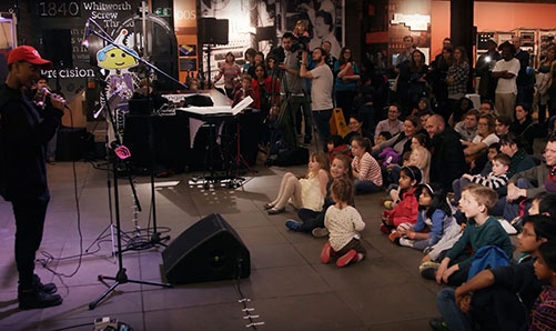 Parents and children watching performance at MOSI's Robot Orchestra