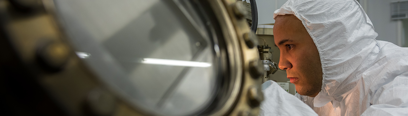 A male researcher operating a molecular beam epitaxy