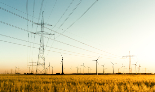 Pylons and wind turbines in the sun