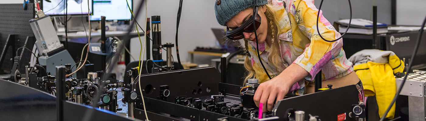 Researcher crouched over equipment in the PSI