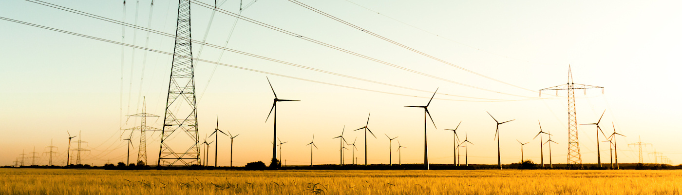 Pylons and wind turbines in the sun