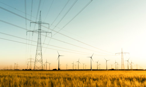 Pylons and wind turbines in the sun