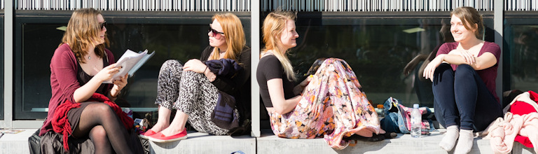 Four female students sat talking outside