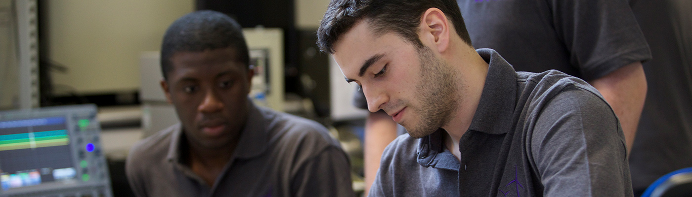 Two students fixing machinery