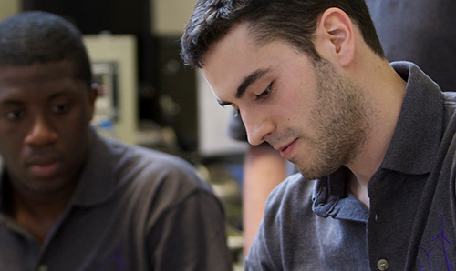 Two students fixing machinery