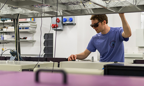 Student in safety glasses using equipment